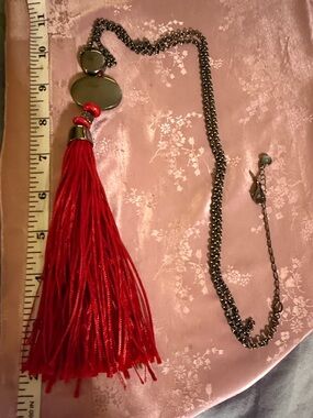 Red tassel and gun medal colored statement necklace